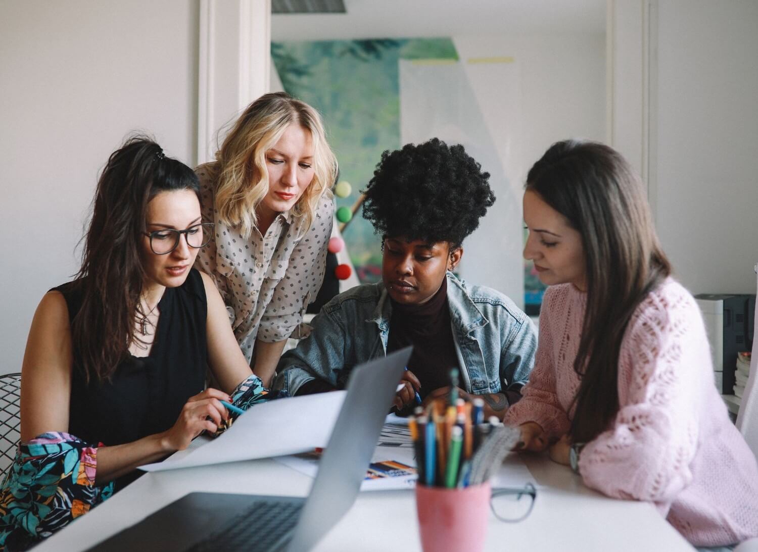 5 women looking over proposal for impact generosity.