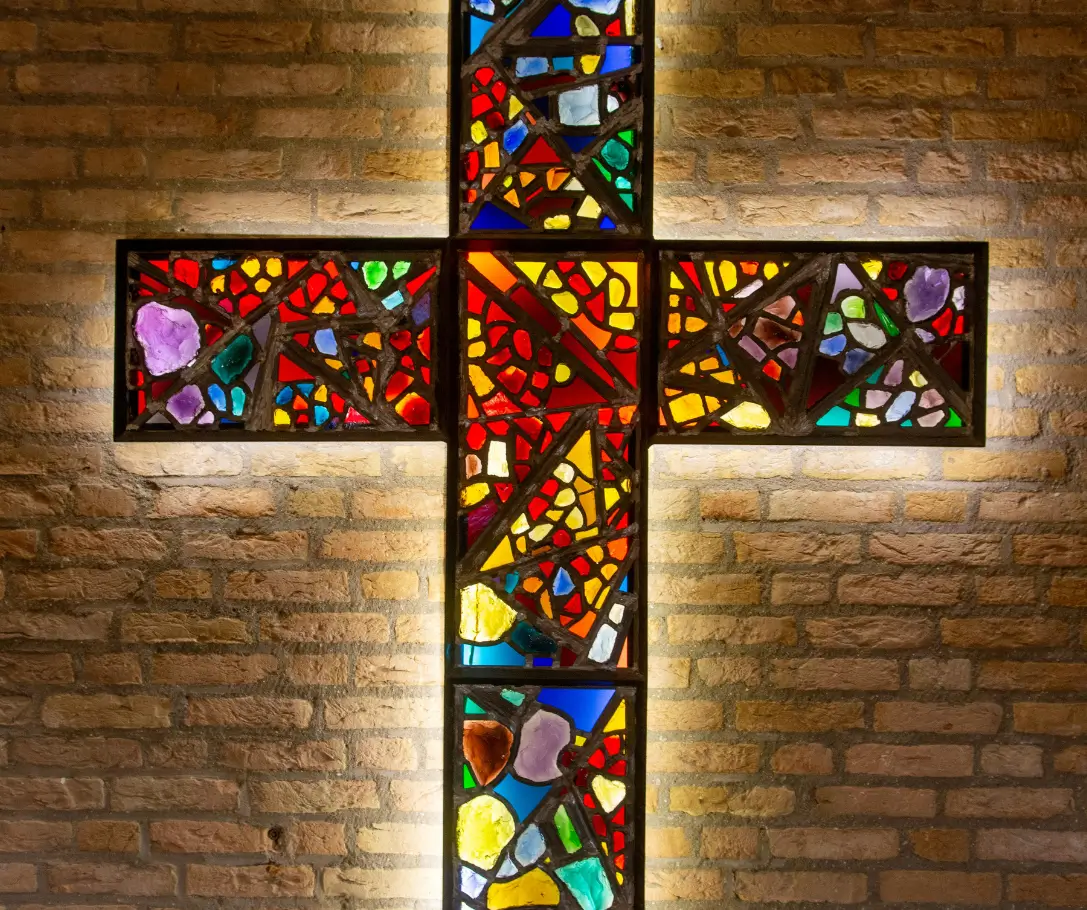 Stained glass cross in front of church representing Impact Generosity Church Support.